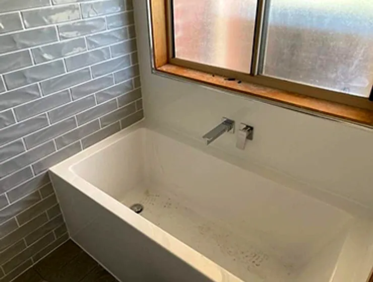 New bath with subway tiling and wall mixer