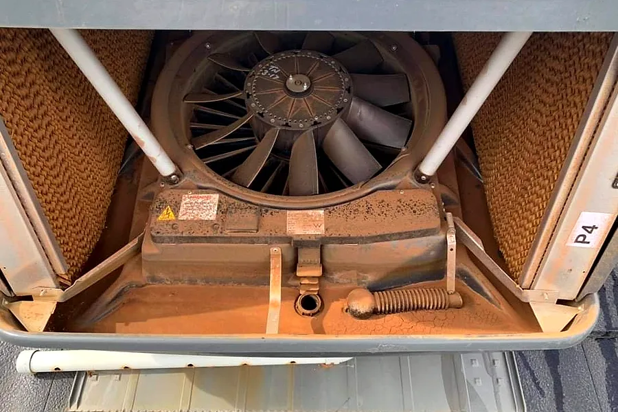 Evaporative cooler fan and pads serviced on a roof