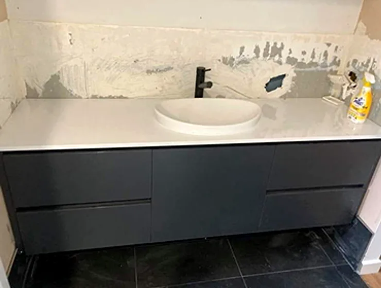 New vanity with stone top and matte black tapware